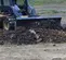 photo of man using dozer blade attachment on a skid steer outside