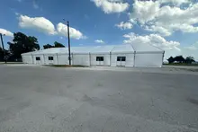 Construction of a fabric structure with a metal frame and a crane in a field, showcasing eco-friendly building practices.