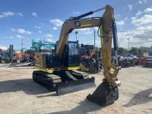 Parked excavator, positioned near safety barriers used for site control and hazard prevention.